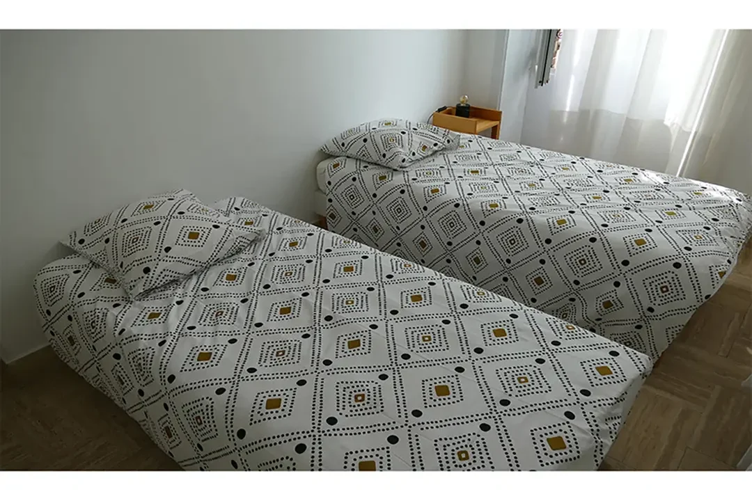 2 lits simples Gîte le Lido maison avec cour fermée espace extérieur 2 chambres cuisine salle de bain avec douche appartement le roseline confortable moderne accès jardin et extérieur douche cuisine une chambre séparée lit double endroit tranquille Le Lido gîte et logement